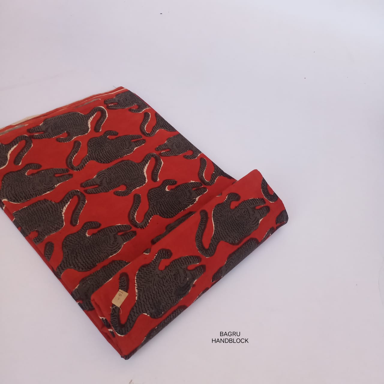 Vibrant red Bagru handblock printed fabric with animal motifs, pure cotton material for creative apparel design.